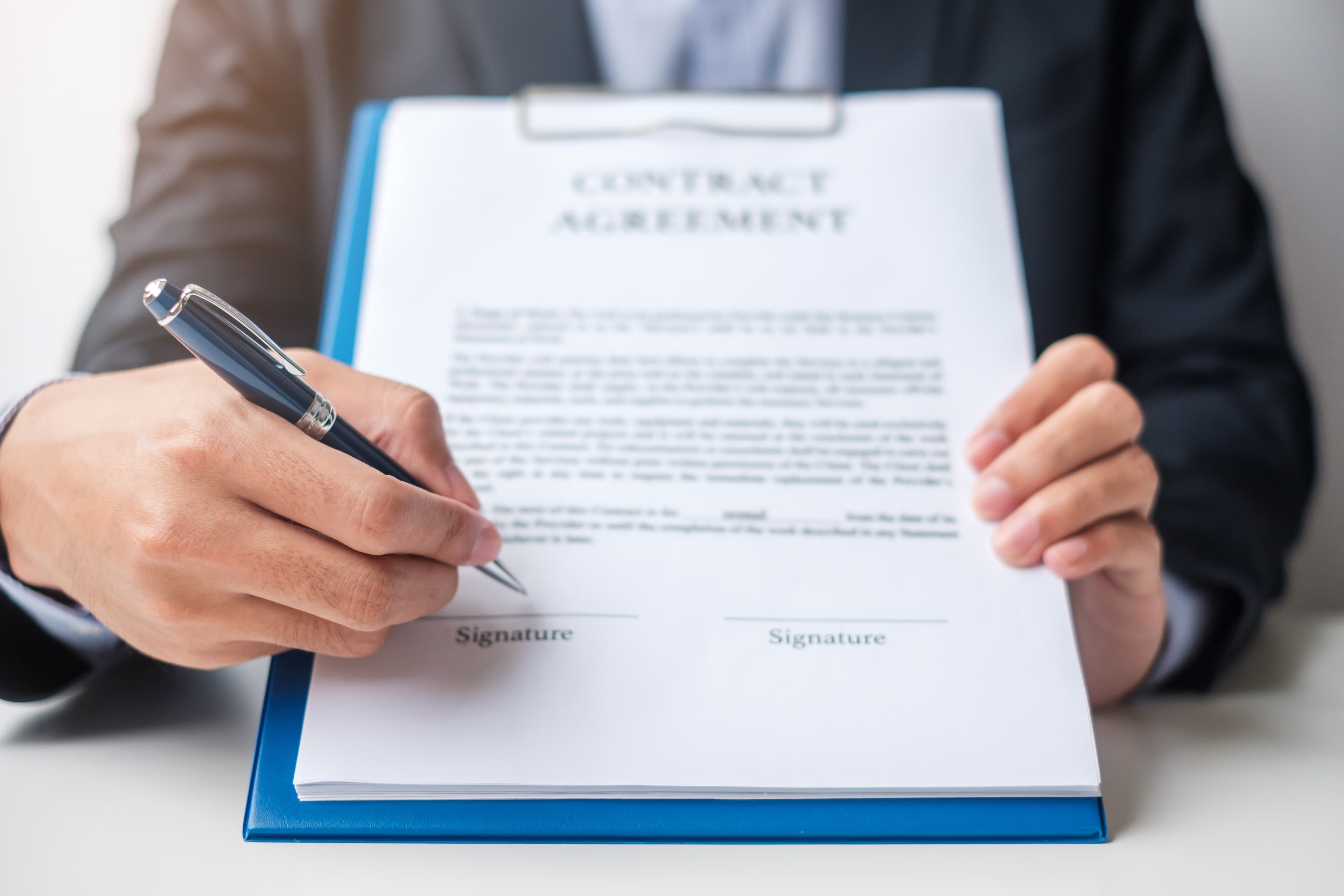 Business owner signing unsecured loan documents at their desk